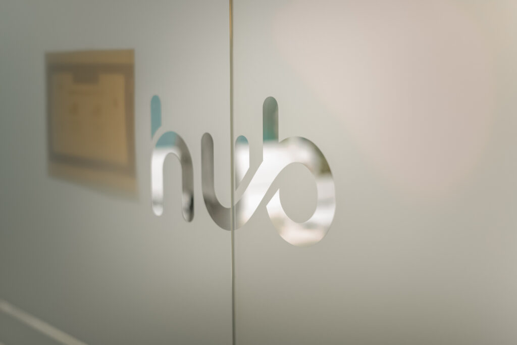 Il logo Hub sulla vetrata d'ingresso dello spazio di coworking a Cesena